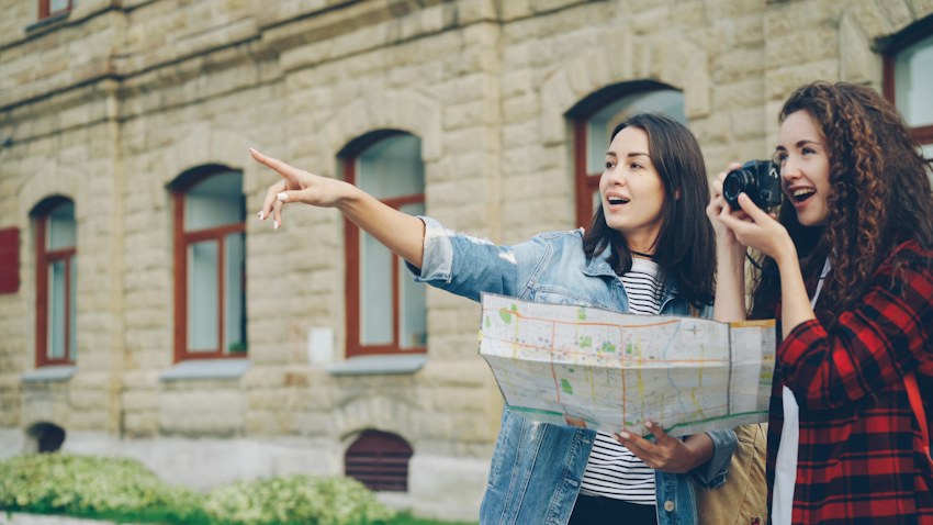 Dos viajeras recorriendo una ciudad con un mapa